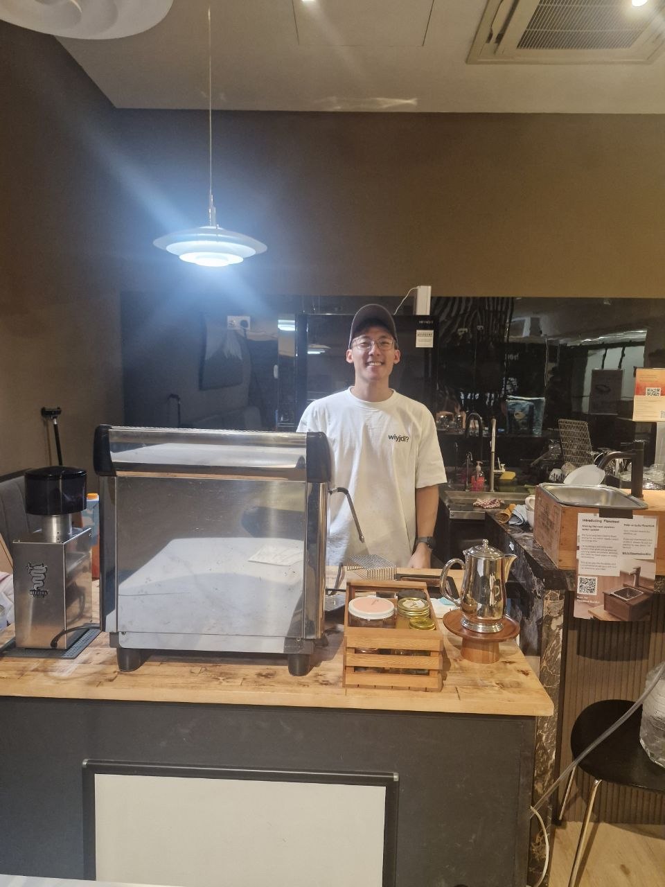 Chun Hou, founder of Element Coffee, smiling behind the bar